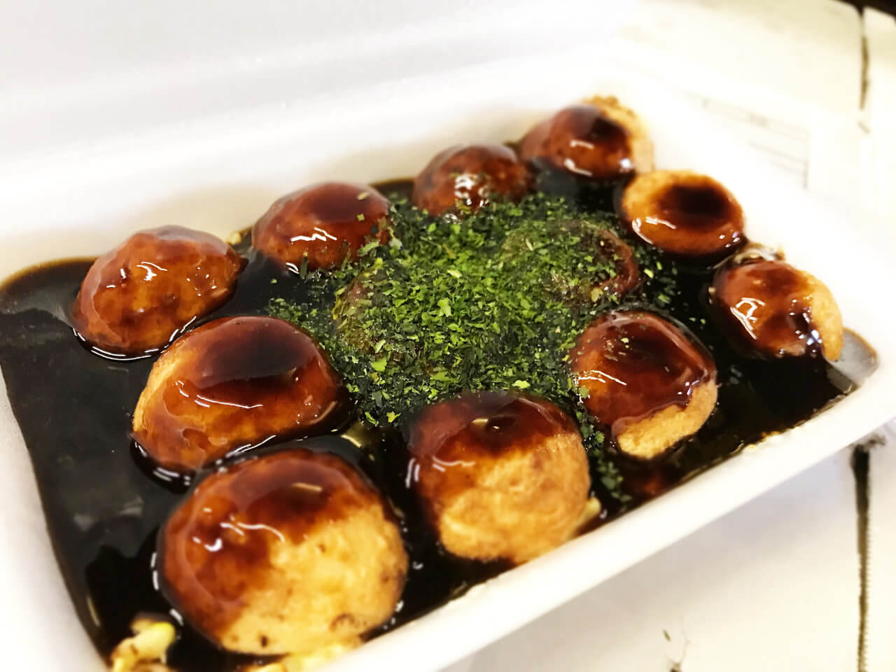 秘伝のソースをたっぷりかけた、とみ流のたこ焼